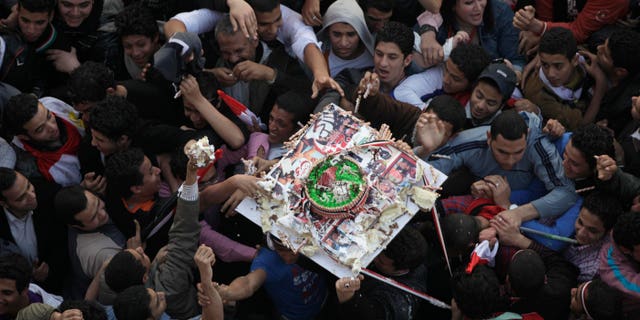 Demonstrators grab pieces of a cake as it is passed above their heads during a rally in Tahrir Square in Cairo, Egypt, Friday Feb. 18, 2011. Some thousands of flag-waving Egyptians packed into Tahrir Square for a day of prayer and celebration Friday to mark the fall of longtime leader Hosni Mubarak a week ago and to maintain pressure on the new military rulers to steer the country toward democratic reforms.