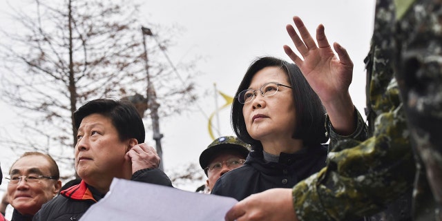 In this photo released by the Taiwan Presidential Office, Taiwan's President Tsai Ing-wen, center, is briefed at the site of a collapsed building from an earthquake.