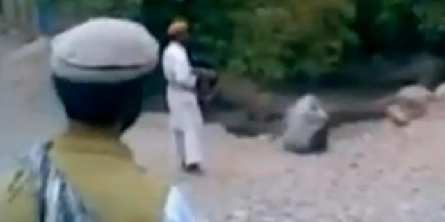 This image taken from a Reuters video allegedly shows a woman being executed by a purported member of the Taliban.