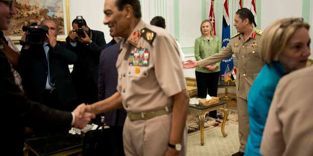 July 15, 2012: US Secretary of State Hillary Rodham Clinton, back center, watches as Field Marshal Hussein Tantawi, second left, greets members of the American delegation before a meeting at the Ministry of Defense in Cairo, Egypt.