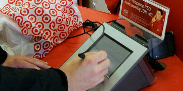 In this Jan. 18, 2008 file photo, a customer signs his credit card receipt at a Target store in Tallahassee, Fla. The U.S. is the juiciest target for hackers hunting credit card information. And experts say incidents like the recent data theft at Target's stores will get worse before they get better. That's in part because U.S. credit and debit cards rely on an easy-to-copy magnetic strip on the back of the card, which stores account information using the same technology as cassette tapes.