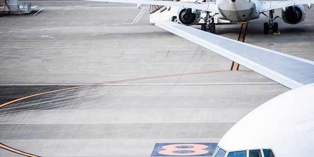 An airport worker celebrated with a dance after successfully flipping a cone onto a stack.