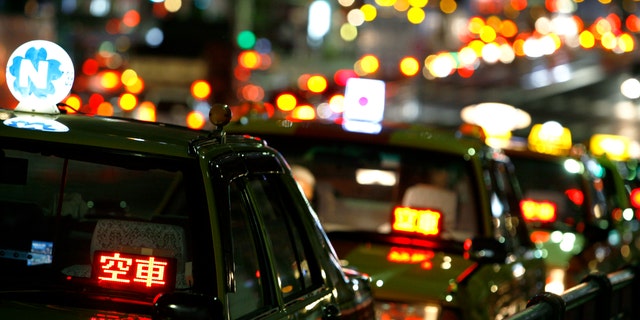 Taxis are parked as drivers wait for customers on a road in Tokyo Aug. 3, 2009. 