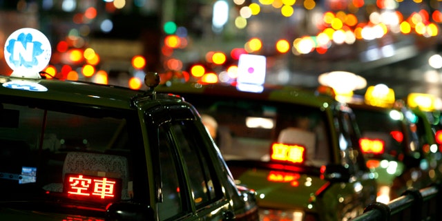 Taxis are parked as drivers wait for customers on a road in Tokyo Aug. 3, 2009.