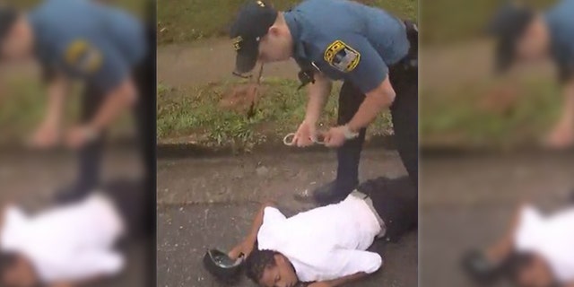 Image from bodycam video showing Timmy Patmon, 23, being handcuffed after being struck by a patrol car driven by Officer Taylor Saulters in east Athens, Georgia.