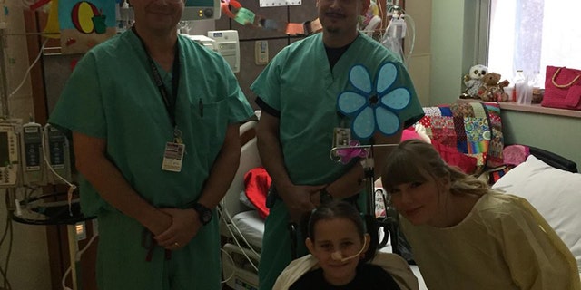 Taylor Swift poses with doctors and a young fan.