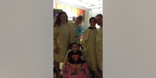 Taylor Swift Poses with a young fan's family at a Phoenix hospital.