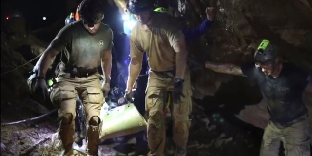 This undated photo from video released via the Thai NavySEAL Facebook Page on Wednesday, July 11, 2018, shows rescuers hold an evacuated boy inside the Tham Luang Nang Non cave in Mae Sai, Chiang Rai province, in northern Thailand.