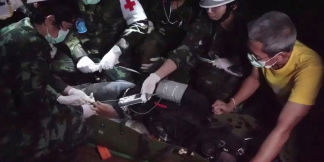 This undated photo from video released via the Thai NavySEAL Facebook Page on Wednesday, July 11, 2018, shows rescuers hold an evacuated boy inside the Tham Luang Nang Non cave in Mae Sai, Chiang Rai province, in northern Thailand.