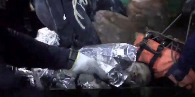 This undated photo from video released via the Thai NavySEAL Facebook Page on Wednesday, July 11, 2018, shows rescuers hold an evacuated boy inside the Tham Luang Nang Non cave in Mae Sai, Chiang Rai province, in northern Thailand.