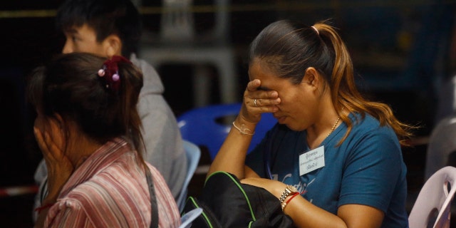 Family members react after hearing the news that the missing 12 boys and their soccer coach have been found, in Mae Sai, Chiang Rai province, in northern Thailand.