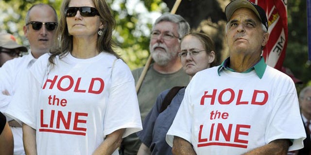 FIle: Tea Party supporters wear 'Hold the Line' t-shirts as dozens rallied near the U.S. Capitol against raising the debt limit in Washington July 27.