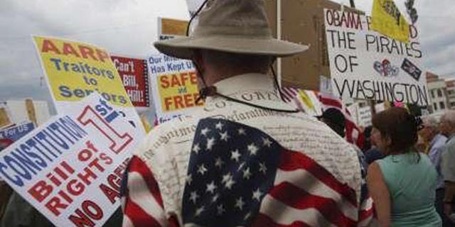 In this Aug. 31 file photo, "tea party" demonstrators hold signs at a protest in Flagstaff, Ariz. (Reuters Photo)