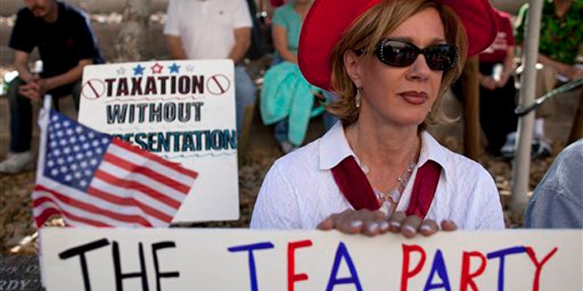 In this April 15 file photo, an activist in Las Vegas listens to speakers during a Tea Party rally.
