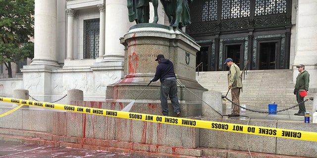 Workers with the New York City Department of Parks and Recreation clean up the Theodore Roosevelt statue.