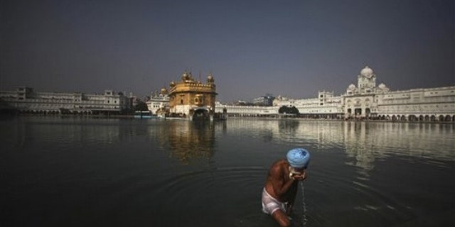 A Sikh devotee drinks water from the holy pond at the Golden Temple in Amritsar, India, on Jan. 4. (AP Photo)