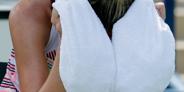 Kristyna Pliskova, of the Czech Republic, cools off with an ice towel during a changeover in her match against Kiki Bertens, of the Netherlands, during the first round of the U.S. Open tennis tournament