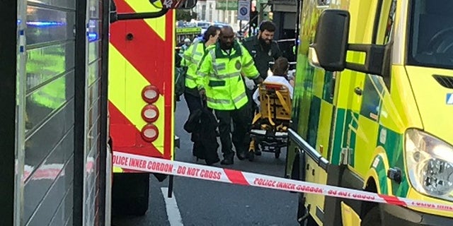 Emergency services help a person after a fire at Parsons Green underground station in London, Britain.
