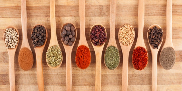various spices on wooden spoons on cutting board