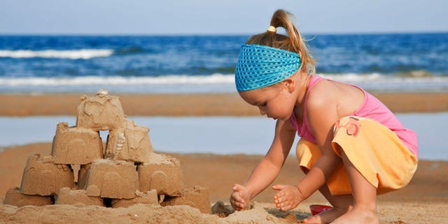 The child builds a sand castle on the beach toy shovel