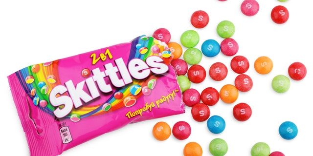 Closeup of unwrapped Skittles candy made by Wm. Wrigley Jr. Company isolated on white background with clipping path