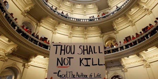 A pro-life protester holds a sign inside the Texas Statehouse in Austin, July 12, 2013 (Reuters)