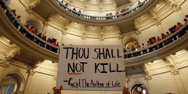 A live demonstrator holds a poster at the Texas Statehouse in Austin, July 12, 2013. (Reuters)