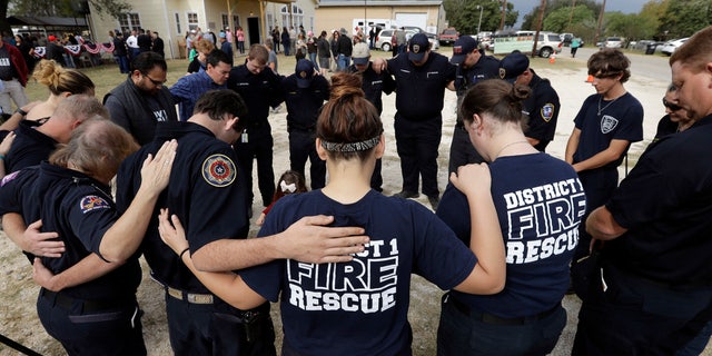 First responders join in prayer following a Veterans Day event, Saturday, Nov. 11, 2017, near the Sutherland Springs First Baptist Church, in Sutherland Springs, Texas.