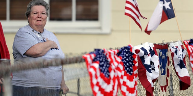 Donna King stands for the national anthem during a Veterans Day event, Saturday, Nov. 11, 2017, in Sutherland Springs, Texas.
