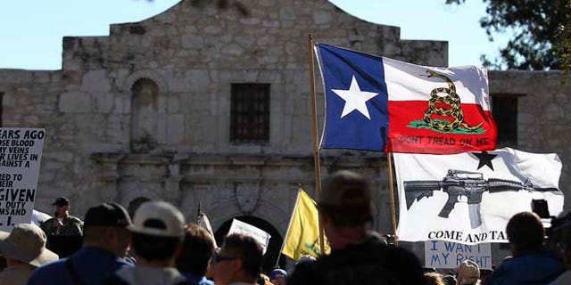Oct. 19, 2013: In this file photo, flags fly at the "Come And Take It San Antonio" rally. Long depicted as the rootin'-tootin' capital of American gun culture, Texas is one of the few states with an outright ban on the open carry of handguns. That could change next year, with an expected push for expanding gun rights from the Republican-dominated Legislature.