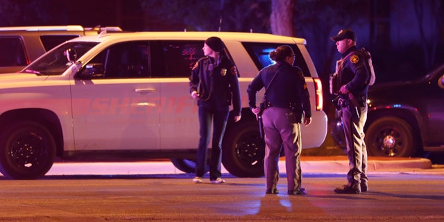 Emergency personnel stage at an intersection across from Talkington Hall on the Texas Tech University campus in Lubbock, Texas, Monday, Oct. 9, 2017. Police apprehended a 19-year-old student accused of fatally shooting a Texas Tech University police officer at the campus police station Monday night. (Mark Rogers/Lubbock Avalanche-Journal via AP)