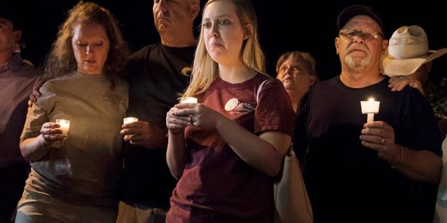 Mourners participate in a candlelight vigil held for the victims of a fatal shooting at the First Baptist Church of Sutherland Springs, Sunday, Nov. 5, 2017, in Sutherland Springs, Texas. (AP Photo/Darren Abate)