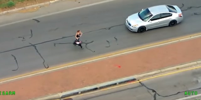 The woman ran with the child through traffic after crashing into another vehicle.