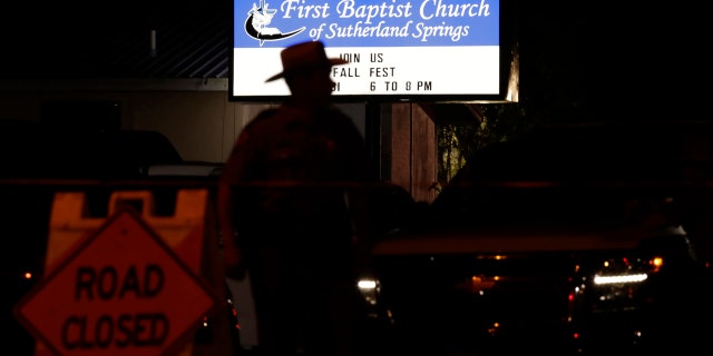 A law enforcement official stands watch outside the First Baptist Church of Sutherland Springs.