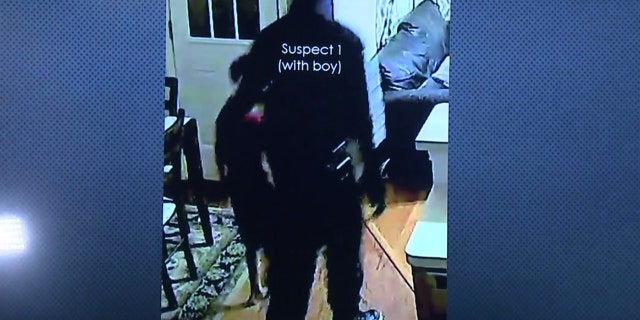 One of the suspects can be seen leading the couple's 7-year-old son around the home looking for money.