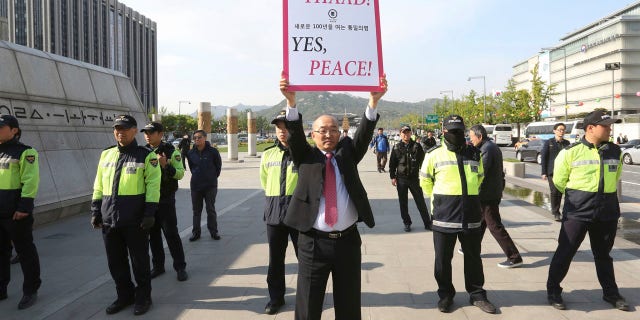 A South Korean protester holds up a placard opposing a plan to deploy the advanced U.S. missile defense system called Terminal High-Altitude Area Defense, or THAAD, near U.S. Embassy in Seoul, South Korea, Thursday, April 27, 2017.