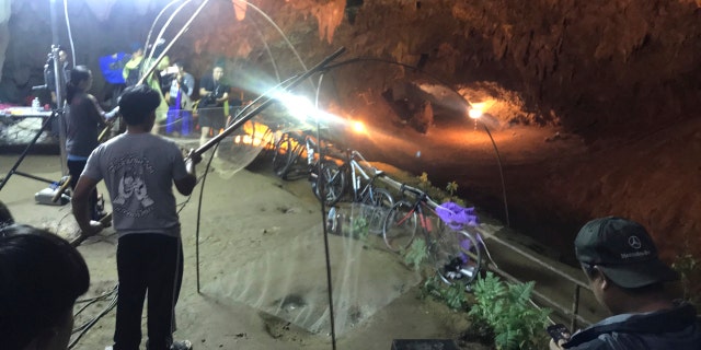 Relatives hold fishing nets, as a symbol to fish out lost spirits inside cave, as a group of locals and relatives perform a ritual calling for those are missing at the entrance of the cave, Tuesday, June 26, 2018, in Mae Sai, Chiang Rai province, northern Thailand.