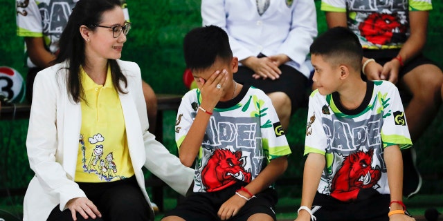 Rescued soccer player "Titan" Chanin Vibulrungruang reacts after paying respect to a portrait of Saman Gunan, the Thai Navy SEAL diver who died in the rescue attempt.