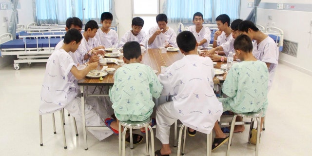 In this Sunday, July 15, 2018, file photo released by Thailand's Ministry of Health and the Chiang Rai Prachanukroh Hospital, some of the rescued soccer team members eat a meal together at a hospital in Chiang Rai, northern Thailand.