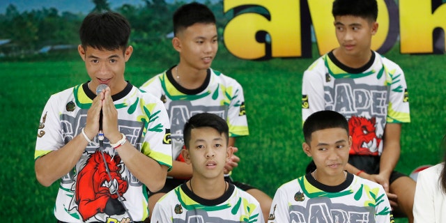 Coach Ekkapol Janthawong, left, and members of the rescued soccer team express their thanks during a press conference discussing their experience of being trapped in a flooded cave.
