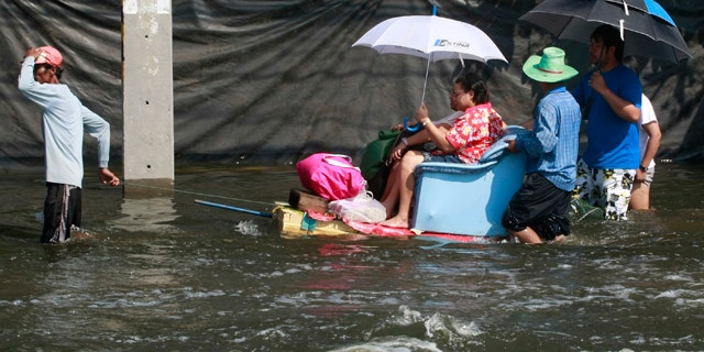 Oct. 24, 2011: A man pulls his decorated boat while making a service to his passenger on a flooded road in Bangkok, Thailand.