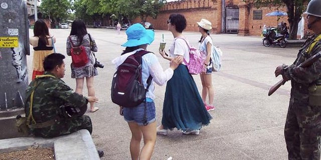 Tourists chat with soldiers in Thailand.