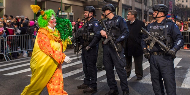 Nov. 26, 2015: A clown marches by heavily armed police stand guard during the Macy's Thanksgiving Day Parade in New York.
