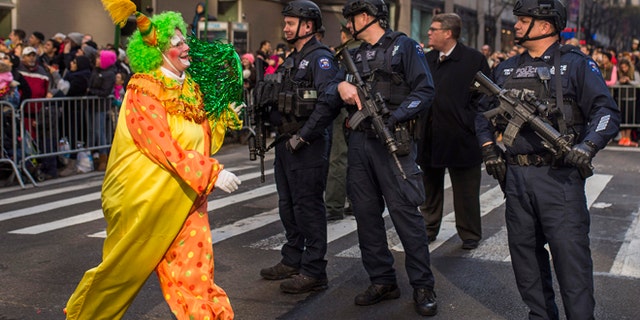 Nov. 26, 2015: A clown marches by heavily armed police stand guard during the Macy's Thanksgiving Day Parade in New York.