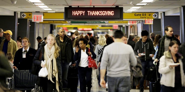 Travelers walk to their gates at LaGuardia Airport in New York ahead of the long Thanksgiving holiday weekend in 2013.