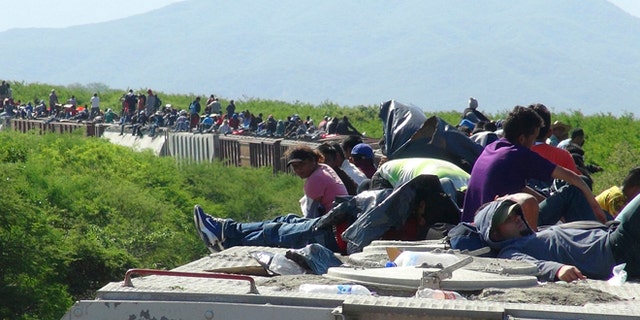 June 18, 2014: People hoping to reach the U.S. ride atop the wagon of a freight train, known as La Bestia (The Beast) in Ixtepec, in the Mexican state of Oaxaca. The train derailed on Wednesday, July 9, leaving about 1,300 migrants stranded, authorities said.
