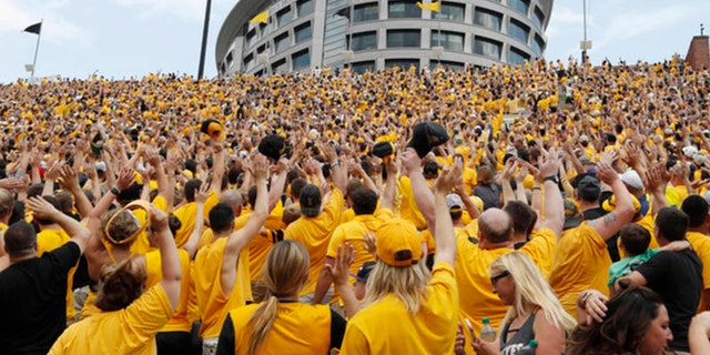 Iowa fans wave to children in the University of Iowa Stead Family Children's Hospital at the end of the first quarter of an NCAA college football game against North Texas, Saturday, Sept. 16, 2017, 