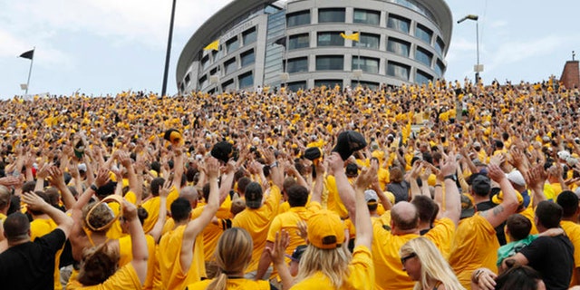 Iowa fans wave to children in the University of Iowa Stead Family Children's Hospital at the end of the first quarter of an NCAA college football game against North Texas, Saturday, Sept. 16, 2017,