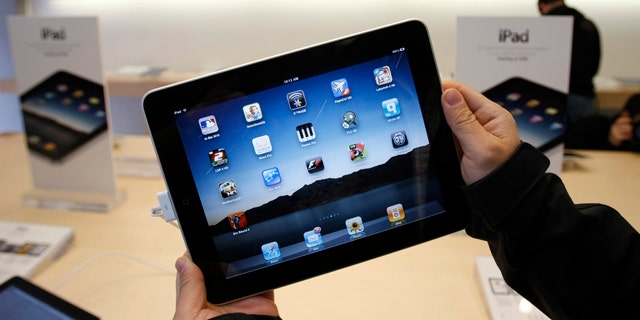 FILE - In this April 3, 2010 file photo showing customer uses an Apple iPad on the first day of Apple iPad sales at an Apple store in San Francisco. (AP Photo/Paul Sakuma, file)
