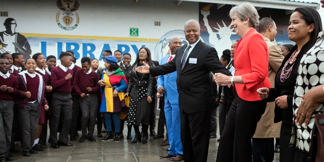 British Prime Minister Theresa May, second from right, dances with pupils during a visit at the the ID Mkhize High School in Gugulethu, Cape Town, South Africa, Tuesday, Aug. 28, 2018.
